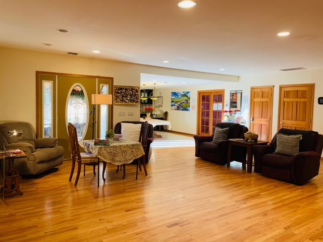 A spacious living room with a dining area, featuring hardwood flooring and comfortable furniture.