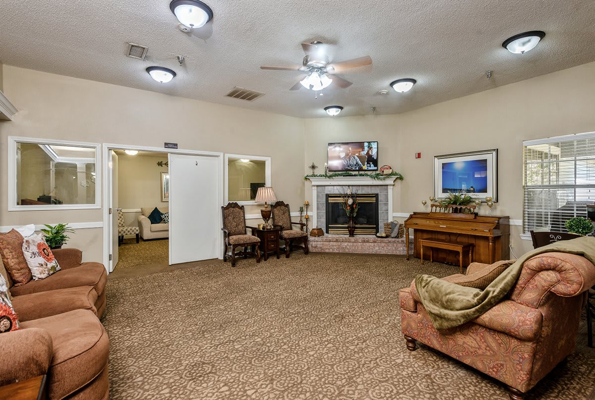A cozy living room with a fireplace, sofas, and a dining table.