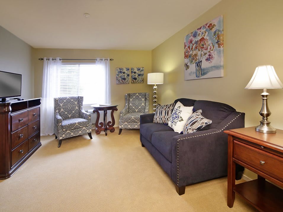A cozy living room with a sofa, armchairs, and decorative elements that create a warm atmosphere.
