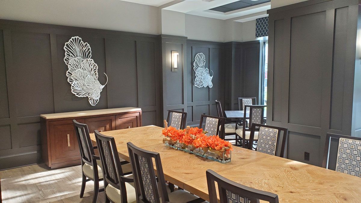 Modern conference room with a large wooden table and artistic wall decor.