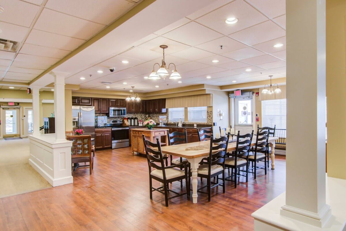 A modern kitchen and dining area with wooden flooring and stylish lighting fixtures.