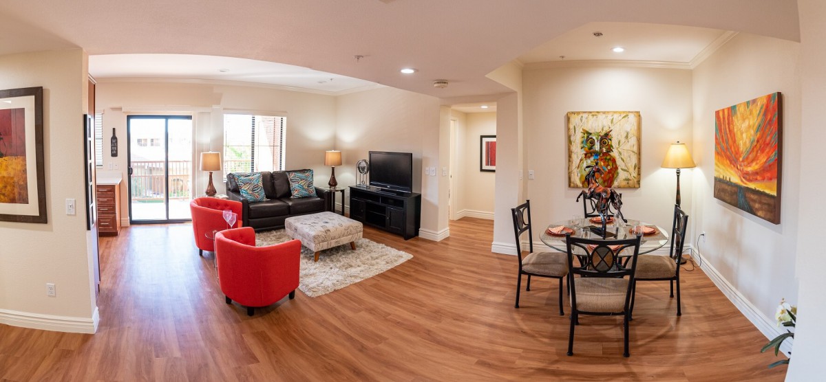 A modern living room with a cozy seating area and an adjoining dining space.