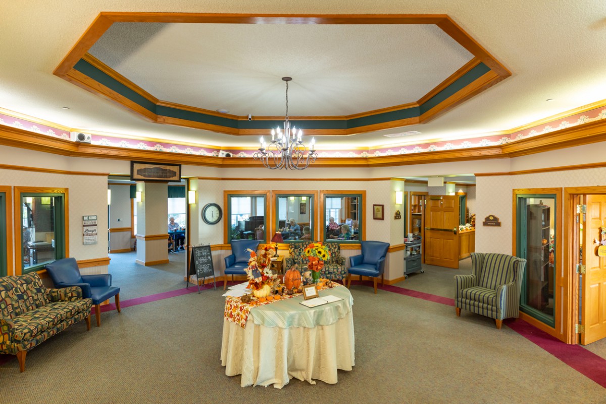 A warmly decorated lobby area with a central table adorned with flowers and surrounded by comfortable seating.