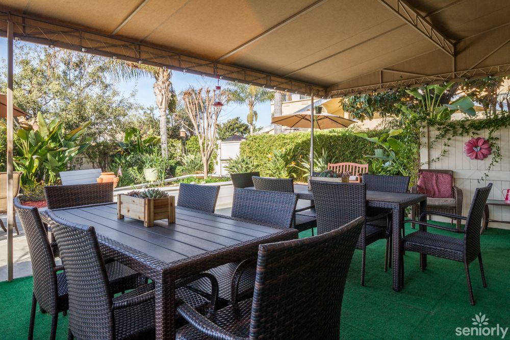 Outdoor patio seating area surrounded by lush greenery.