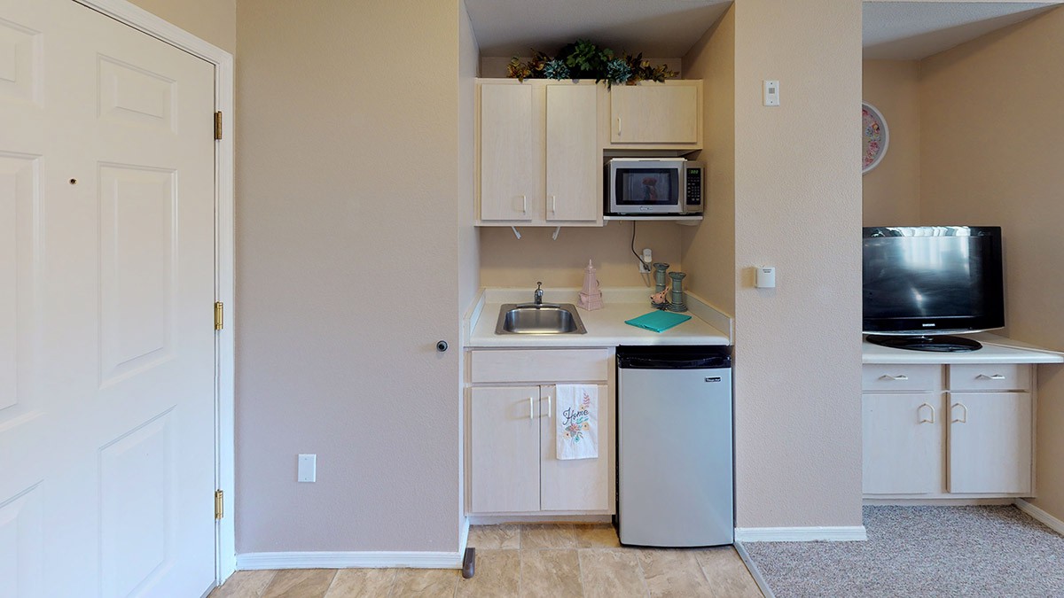 A compact kitchenette with a mini fridge, microwave, and sink.