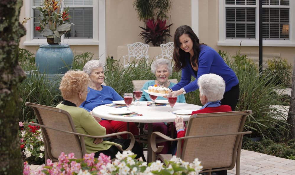 A group of senior women enjoying a meal together outdoors.