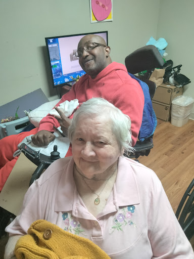 A joyful moment shared between a caregiver and an elderly person, showcasing companionship and support.