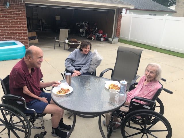 A group of people enjoying a meal together on a patio.