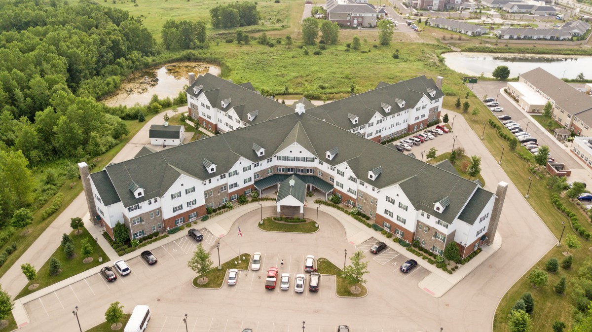 Aerial view of a large residential building with a central courtyard and surrounding greenery.