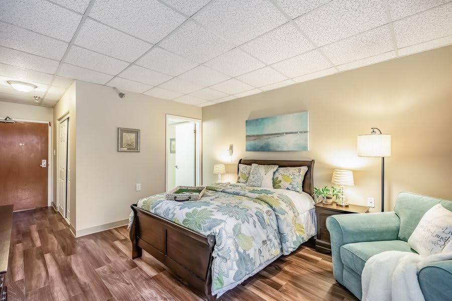 A cozy bedroom with a neatly made bed, elegant furniture, and soft lighting creating a welcoming atmosphere.