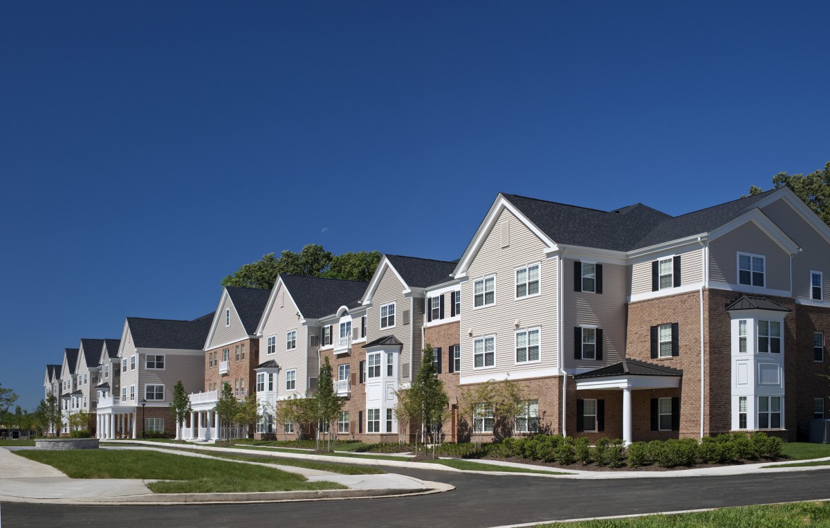 A modern suburban residential housing complex under a clear blue sky.