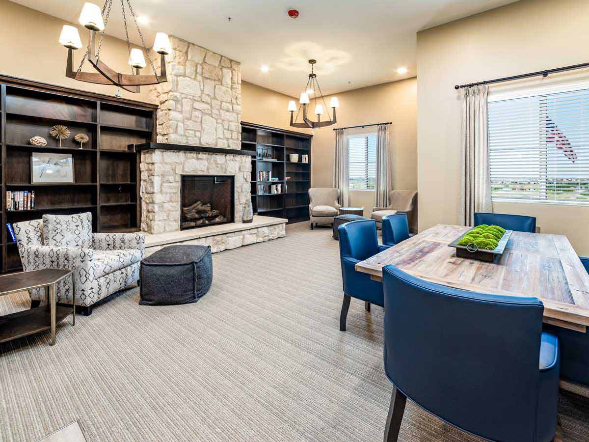 A cozy and modern living room featuring a fireplace, bookshelves, and comfortable seating.