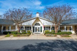 A charming residential building with a landscaped front and clear blue skies.