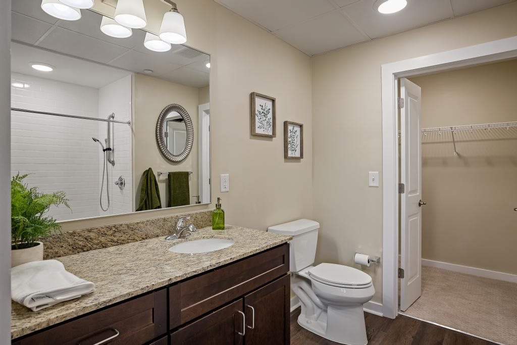 A modern bathroom featuring a sleek vanity, granite countertop, and elegant lighting.