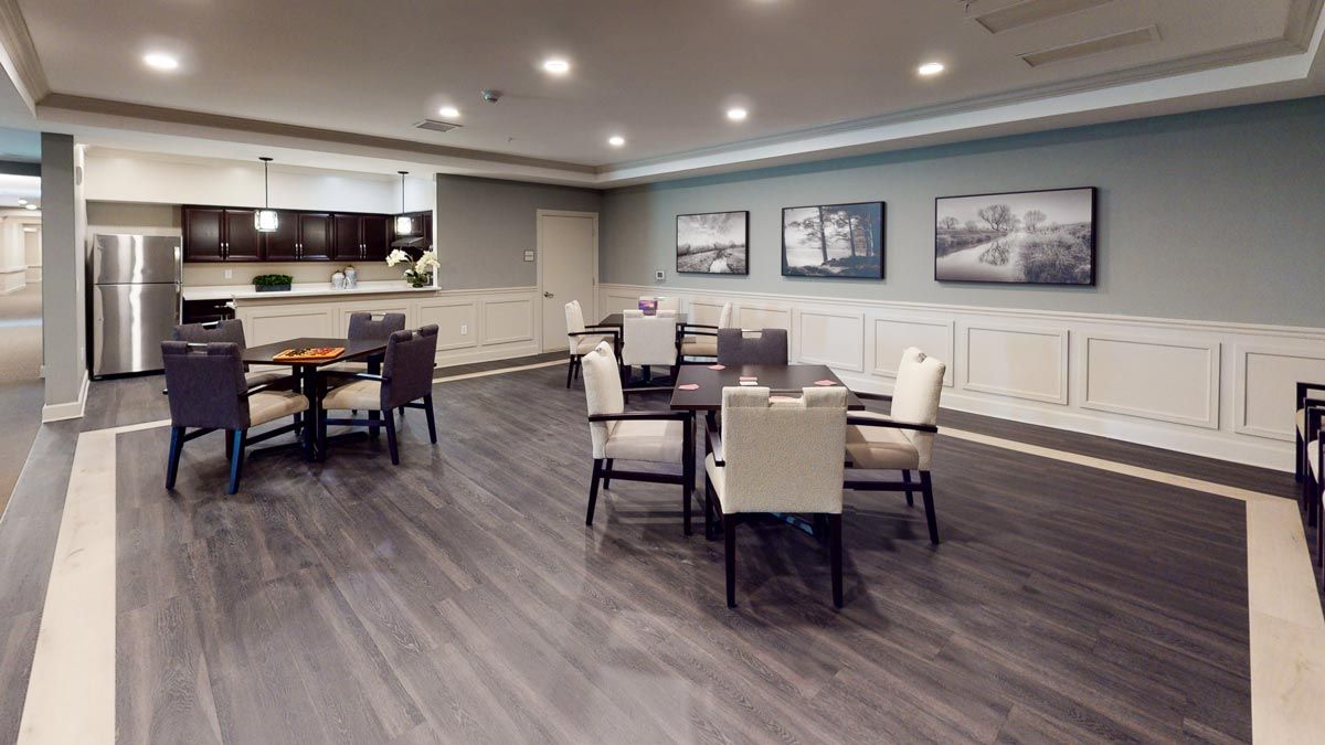 A modern dining area with tables and chairs, featuring stylish lighting and decor.