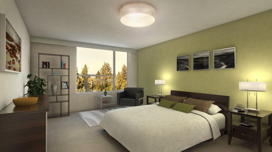 A modern bedroom with a large bed, cozy armchair, and ample natural light from the window.