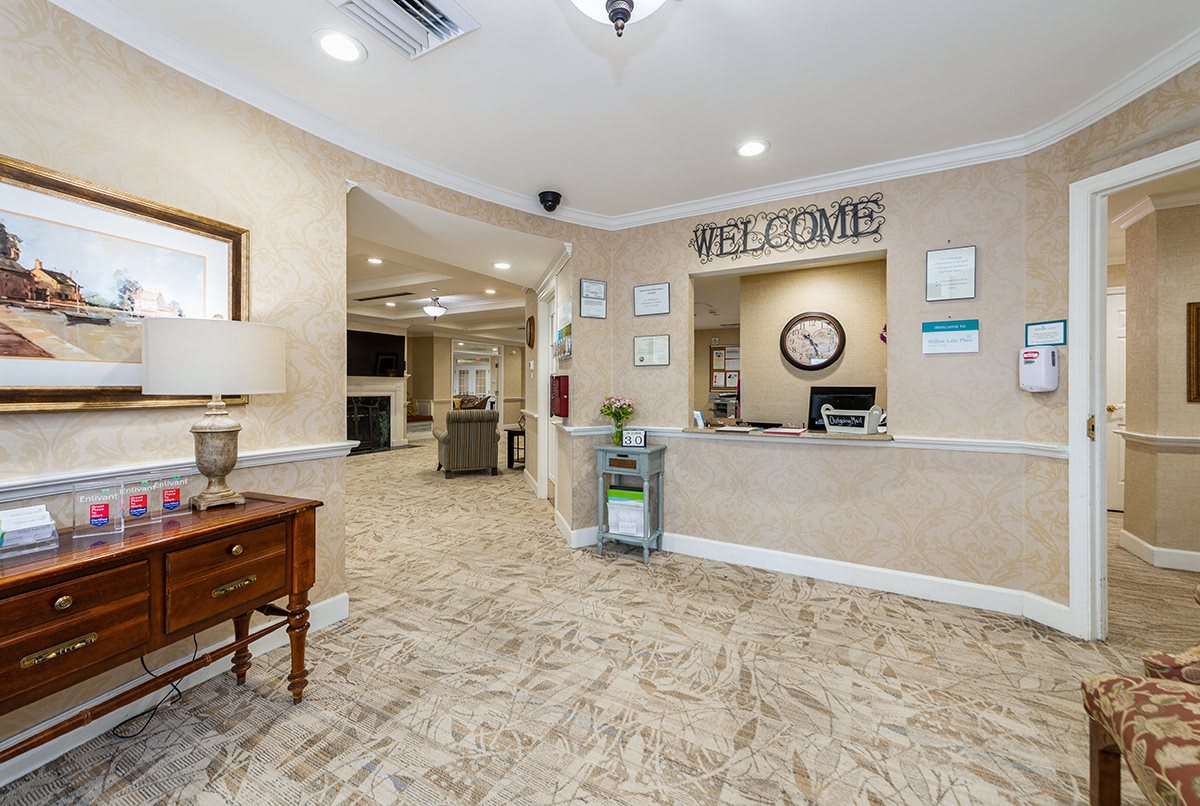 A welcoming reception area with a desk, welcome sign, and comfortable surroundings.