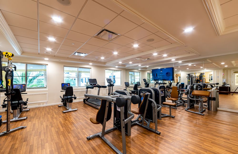 A modern gym with various exercise equipment and cardio machines.
