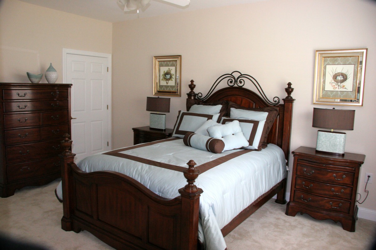 A nicely decorated bedroom with a wooden bed frame and matching furniture.