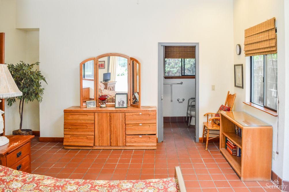A cozy bedroom with wooden furniture and a doorway leading to another room.