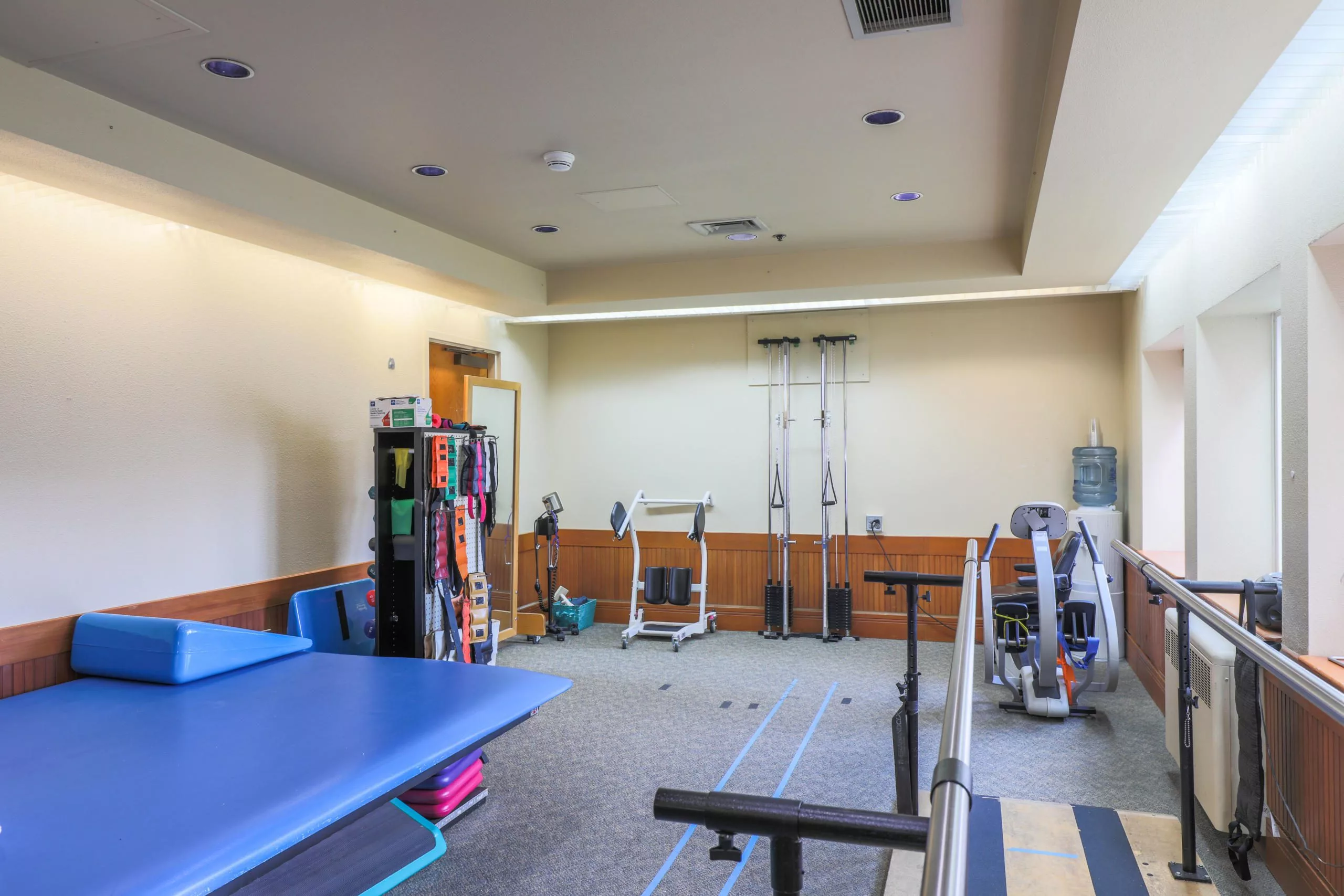 A physical therapy room equipped with various exercise and rehabilitation tools.
