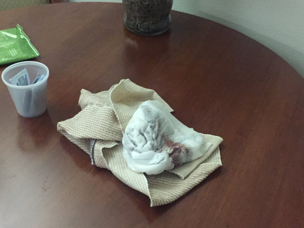 A crumpled towel and cloth napkin on a wooden table.