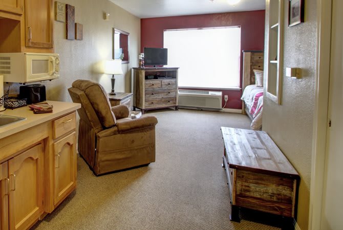 A cozy living room with a comfortable chair, television, and wooden furniture.