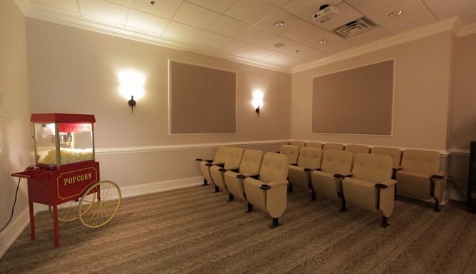 A small theater room with a row of comfortable seating and soft lighting.