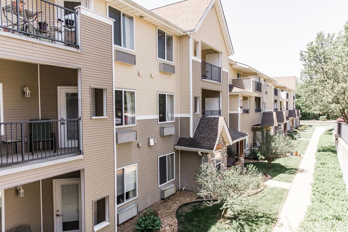 A view of a modern apartment building with balconies and landscaped surroundings.