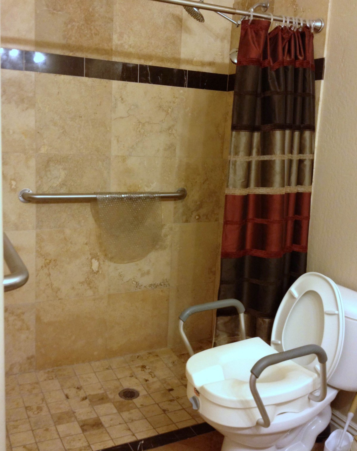 Accessible bathroom with a shower, grab bar, and toilet.