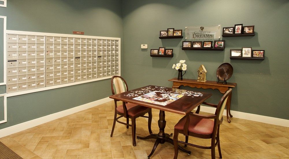 A cozy room with a puzzle on the table, surrounded by chairs and decorative elements.