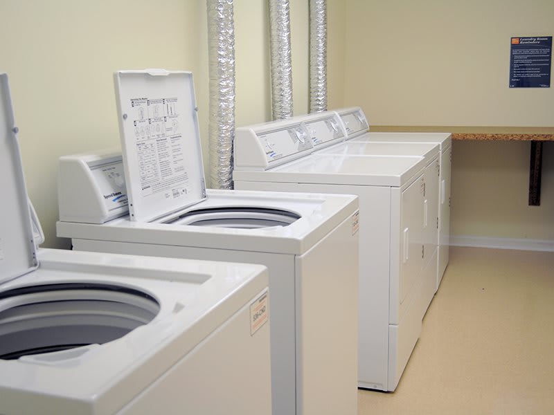A laundry room featuring multiple washing machines lined up along the wall.