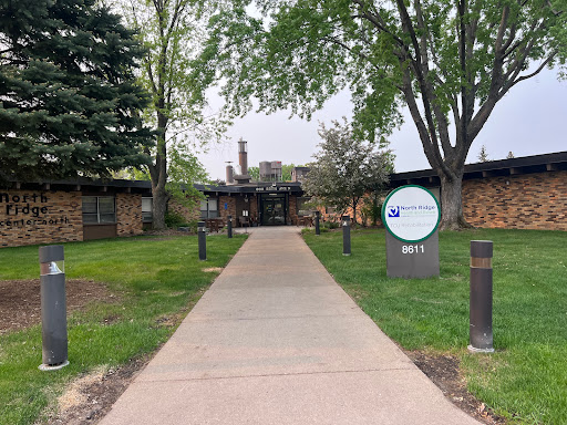 A welcoming entrance path leading to a building surrounded by greenery.