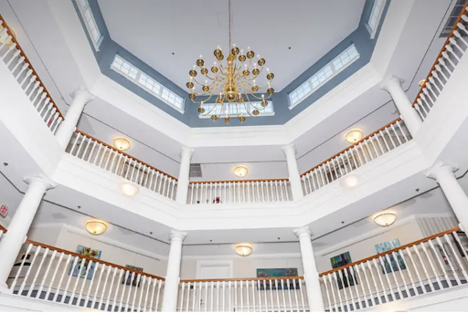 An elegant interior view showcasing a multi-level atrium with a stunning chandelier and stylish railings.