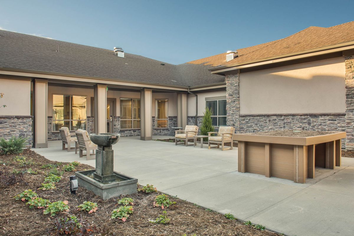 A modern courtyard featuring outdoor seating and a central fountain.