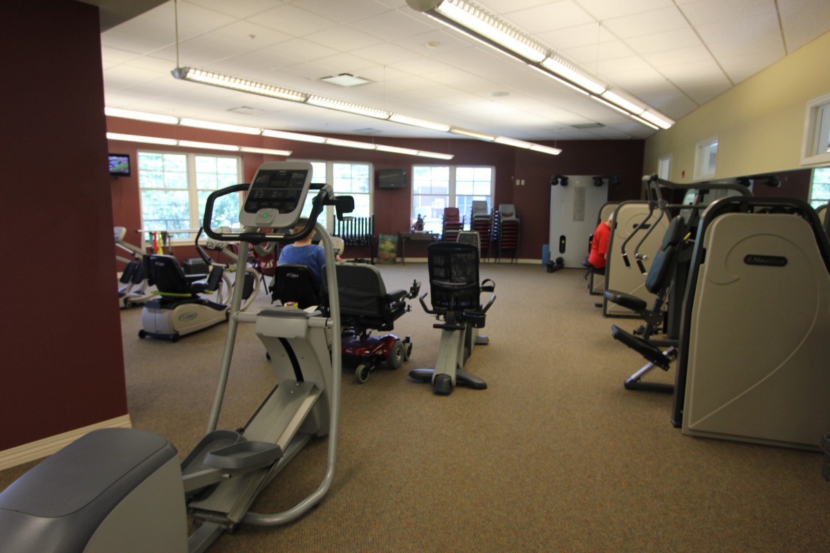 A spacious gym with various exercise equipment and machines.