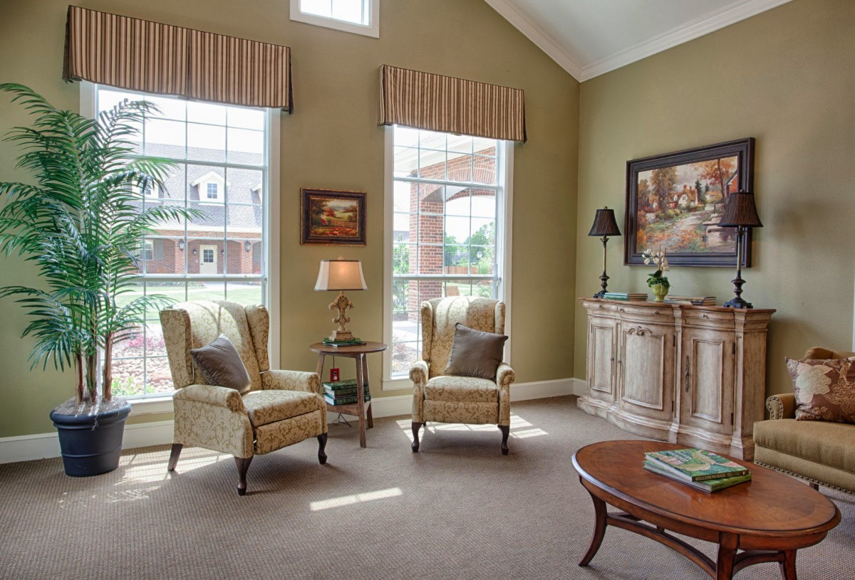 A cozy living room featuring elegant armchairs, a coffee table, and large windows allowing natural light to brighten the space.