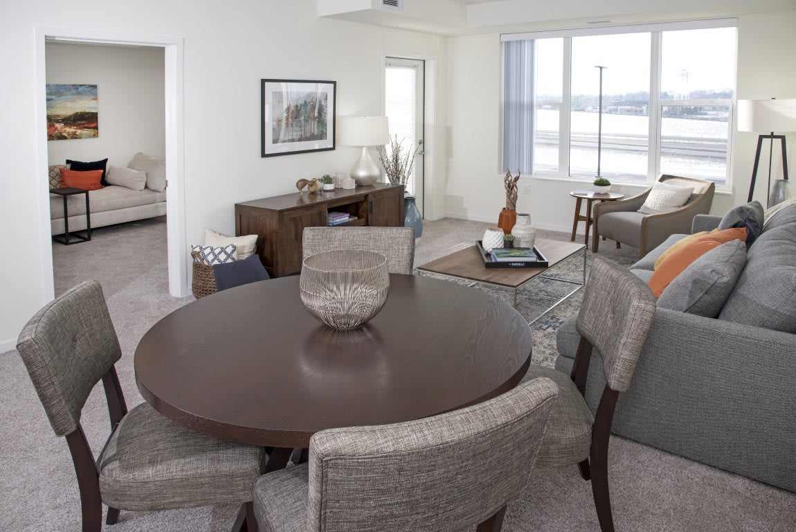 A modern living and dining area with a round table, comfortable chairs, and a cozy living space.