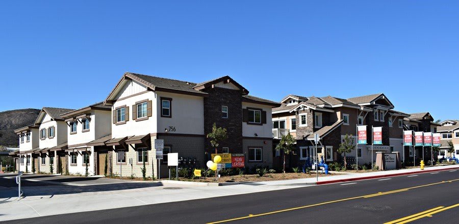 Suburban residential buildings with a clear blue sky backdrop.