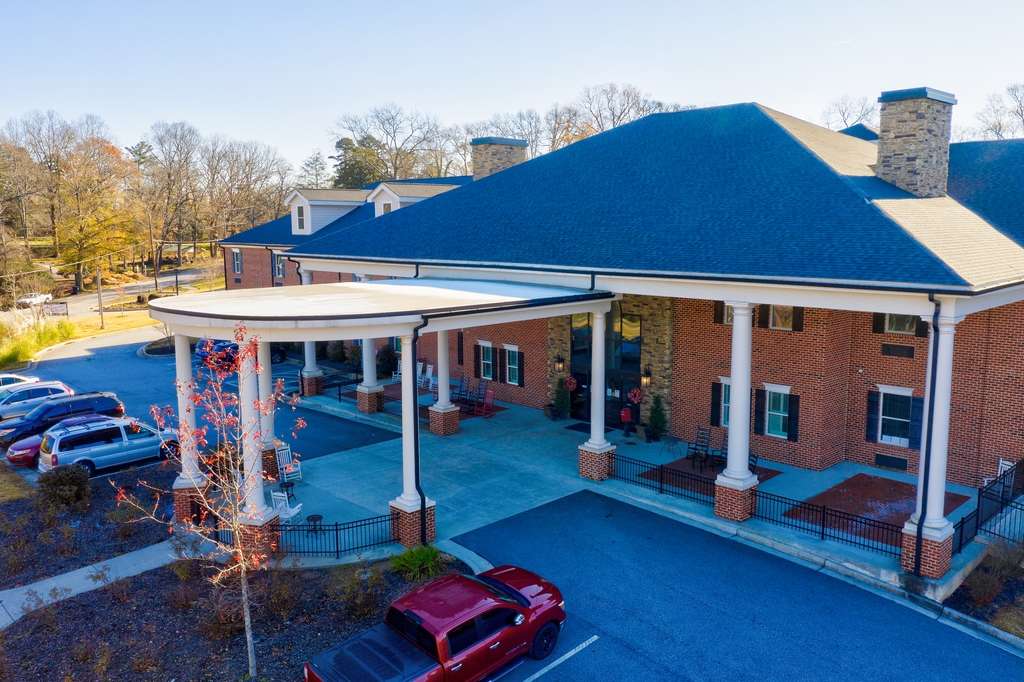 A building entrance with columns and a parking area for vehicles.