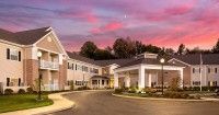 A residential building with a driveway during sunset.
