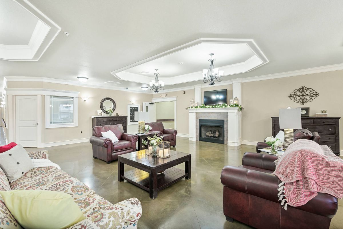 A cozy and well-decorated living room with leather sofas, a central coffee table, and a fireplace.