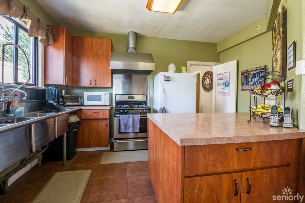 A cozy kitchen featuring wooden cabinets, a kitchen island, and stainless steel appliances.