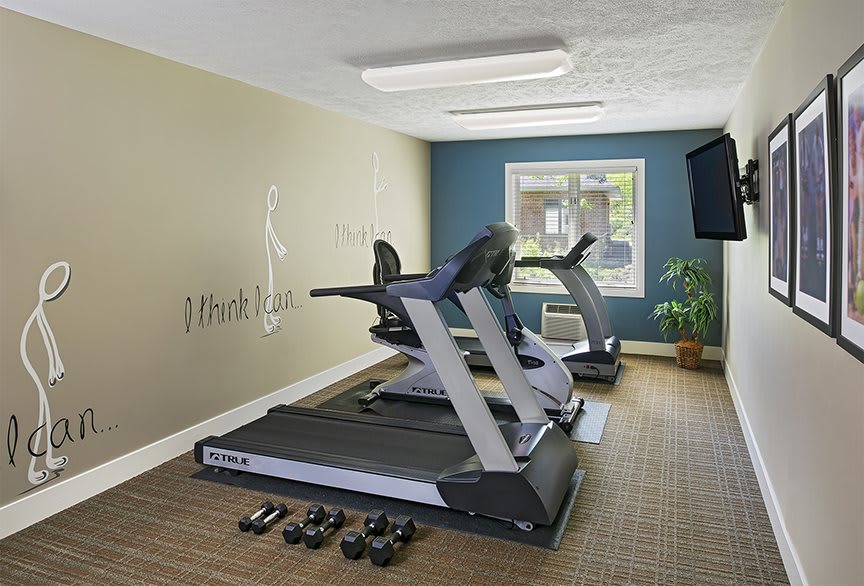 A small fitness room with treadmills and free weights for exercise.