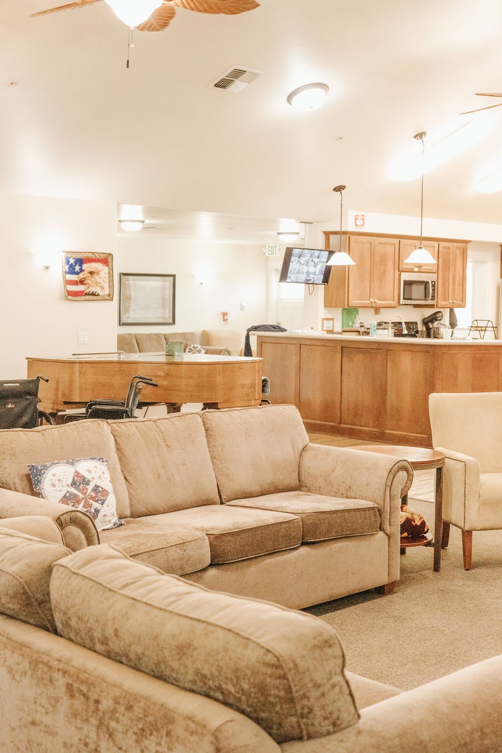 A cozy living room with an open kitchen layout, featuring a comfortable sofa and warm lighting.