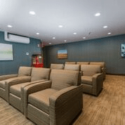 A modern home theater setup with comfortable armchair seating and a minimalist design.