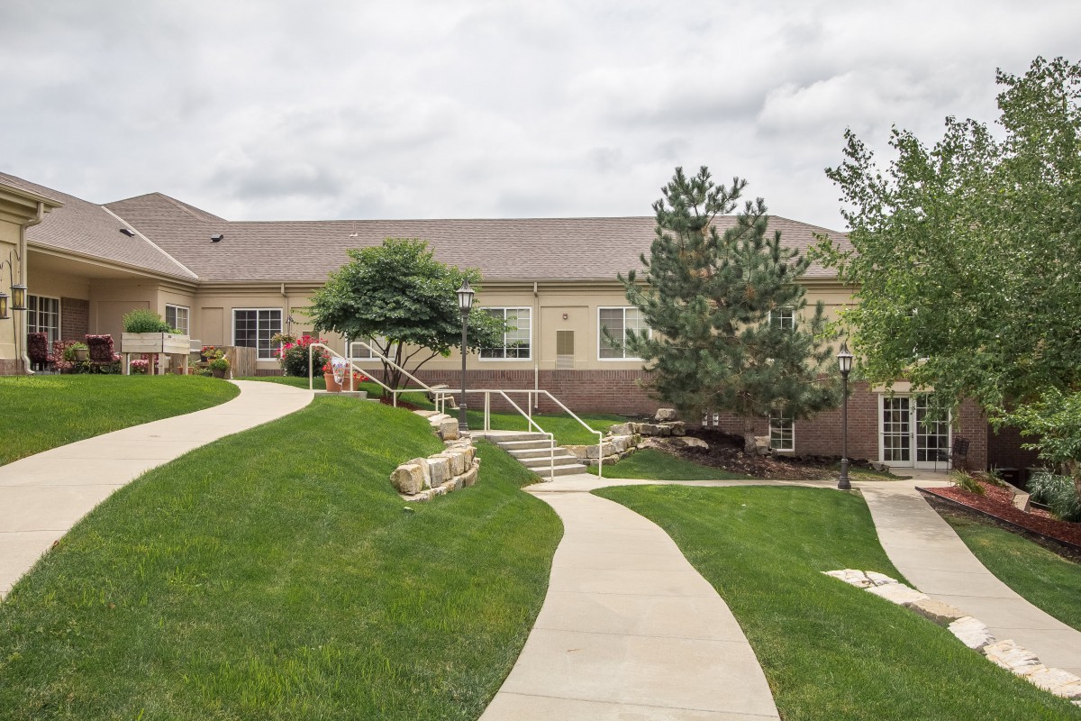 A scenic view of a building with landscaped surroundings and a winding walkway.