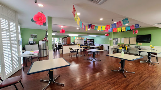 A welcoming dining area featuring green walls, decorative banners, and ample seating.