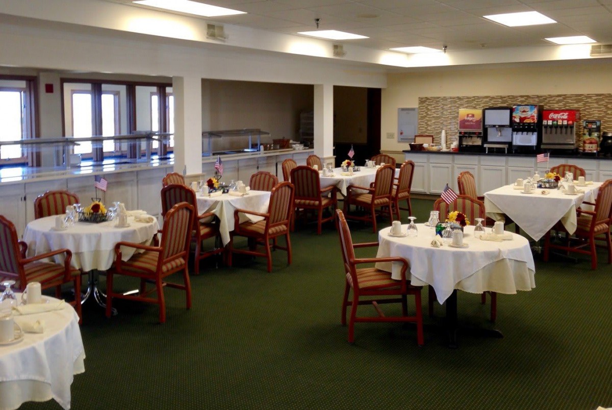A restaurant dining room with tables set for service.