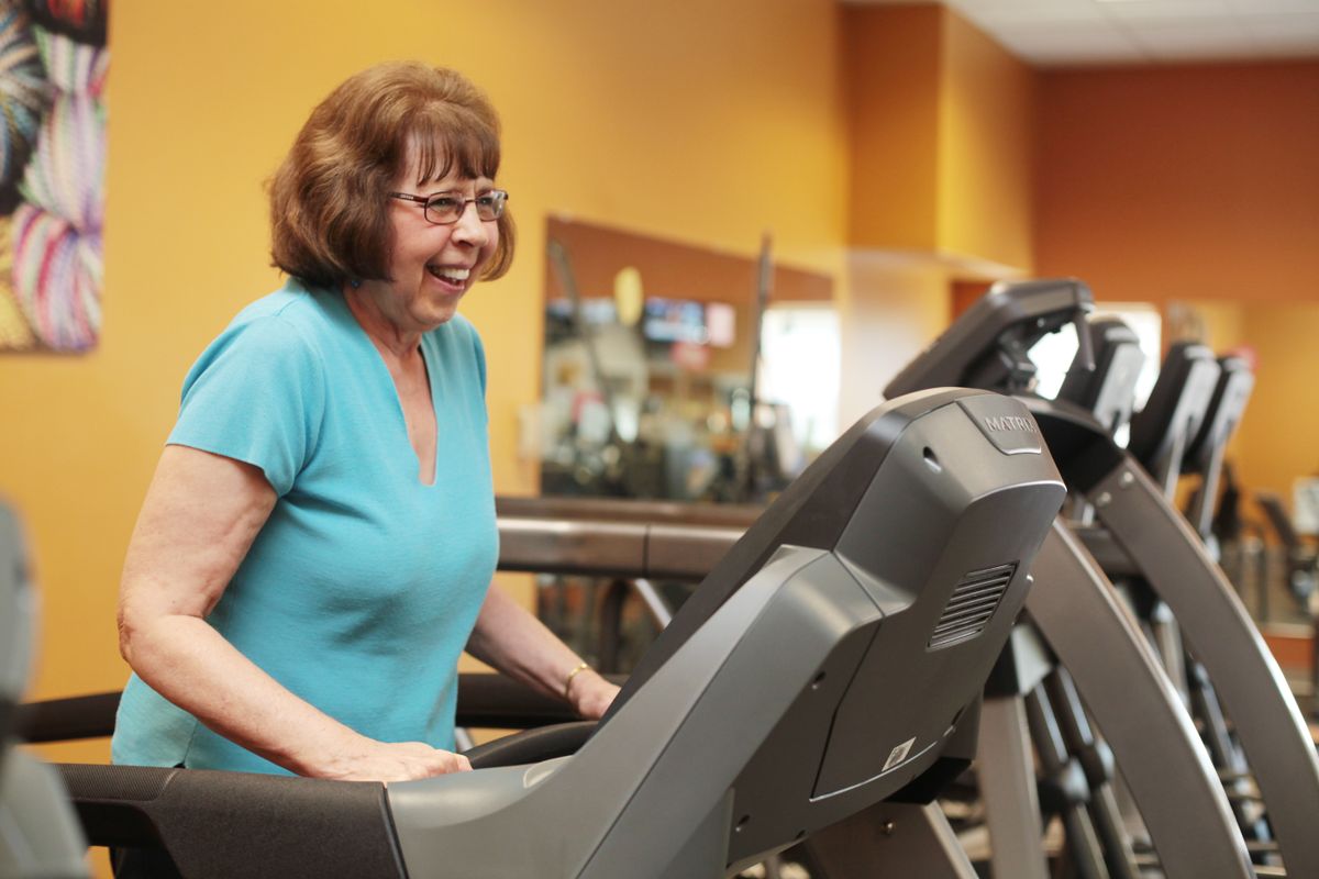 A woman exercising on a treadmill at the gym.